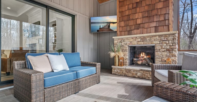Outdoor seating area with a fireplace and television