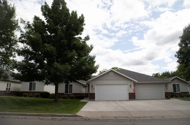 Front view of a residential building at South Hill Village with a large tree.