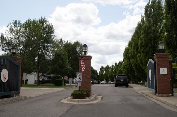 View of the entrance gate at South Hill Village with trees lining the road.
