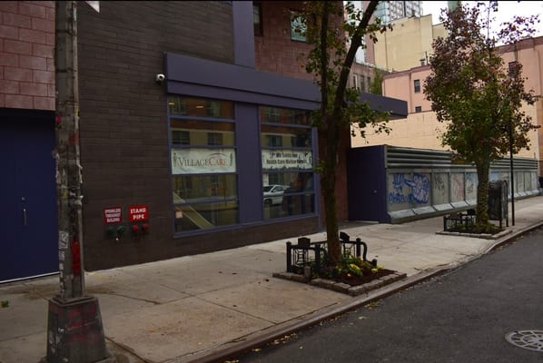 Exterior view of VillageCare at 46 & Ten with a tree and sidewalk in foreground.