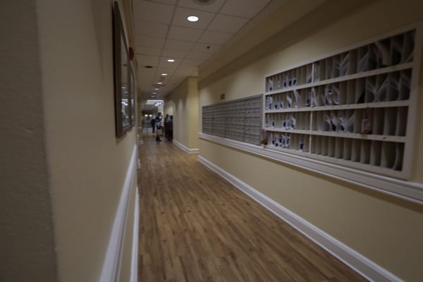 A corridor in a senior living facility with mailboxes.