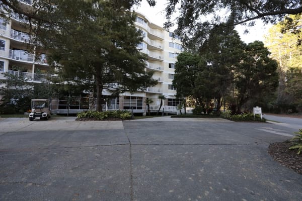 The exterior view of Cypress Village with trees and walkway
