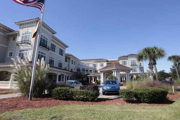 Exterior view of Sunrise of Jacksonville with flag and vehicles