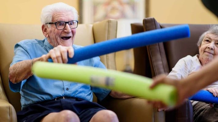Residents engaging in a fun activity with pool noodles