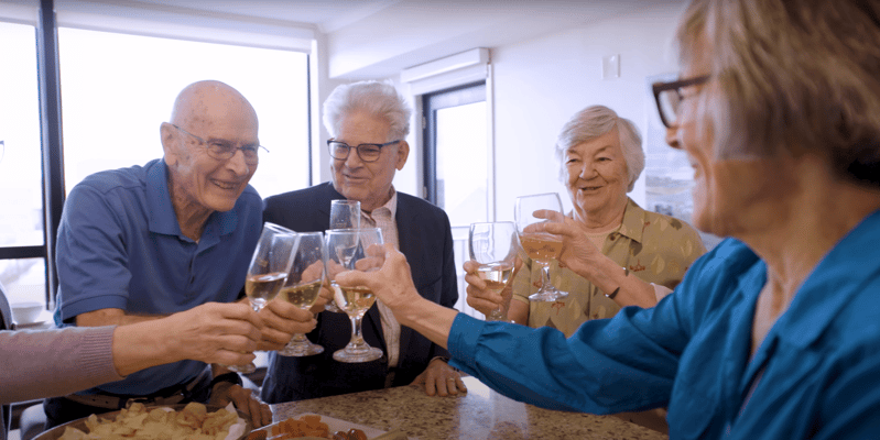 Residents toasting with glasses in a social setting