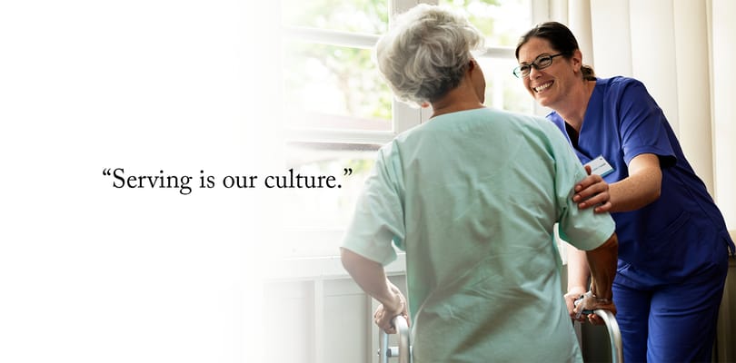 Caregiver assisting a resident with a walker