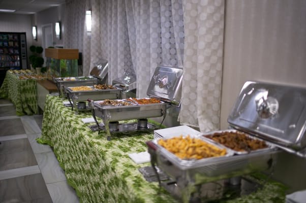 Buffet setup with various food trays in a dining area