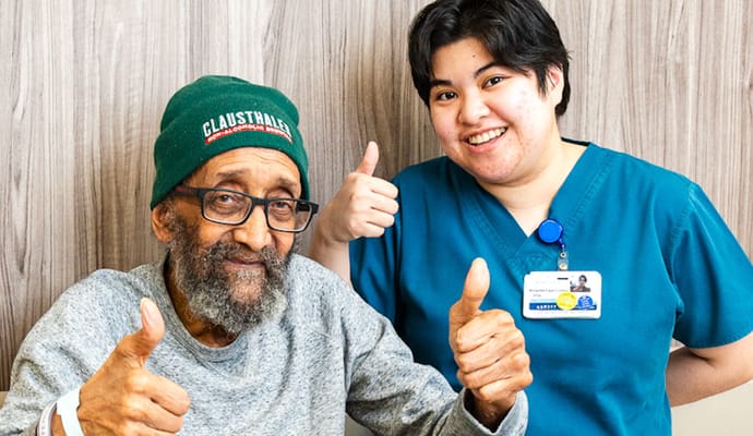 A senior resident and a staff member giving thumbs up