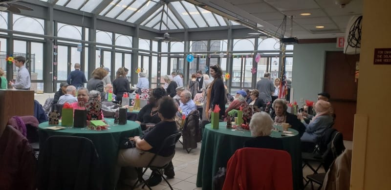 Residents enjoying a lively gathering in a sunlit common area