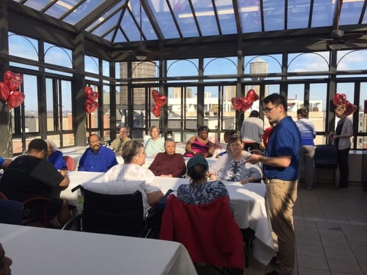 Residents and staff participating in an activity in a sunny common area