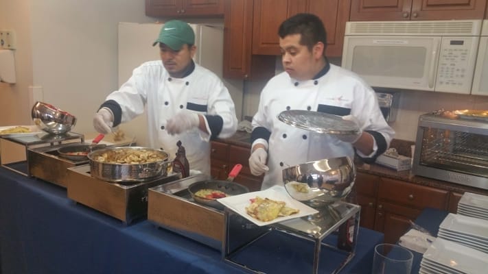 Catering staff serving food in a dining area