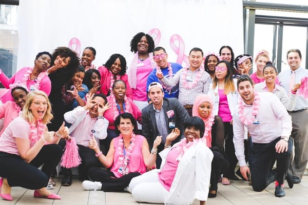 Staff and residents in pink attire posing for a photo