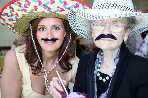 Residents enjoying a fun event with hats and faux mustaches
