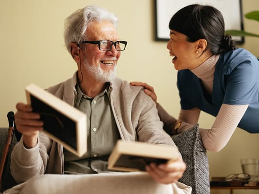 Smiling senior resident interacting with a staff member