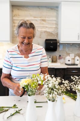 Resident arranging flowers in a bright kitchen area