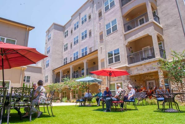 Residents enjoying a sunny outdoor space with seating and shade