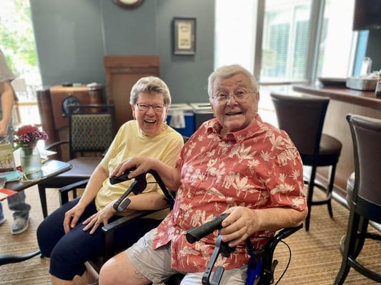 Two residents smiling and enjoying time together indoors