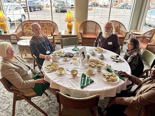 Residents enjoying tea and pastries in a common area