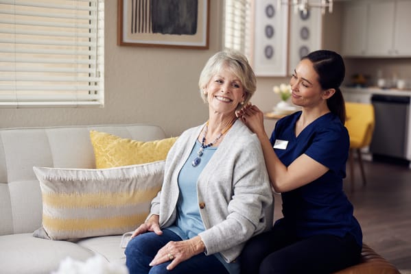 Caregiver assisting a resident in a cozy common area