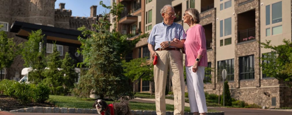 Couple walking with a dog outside a facility