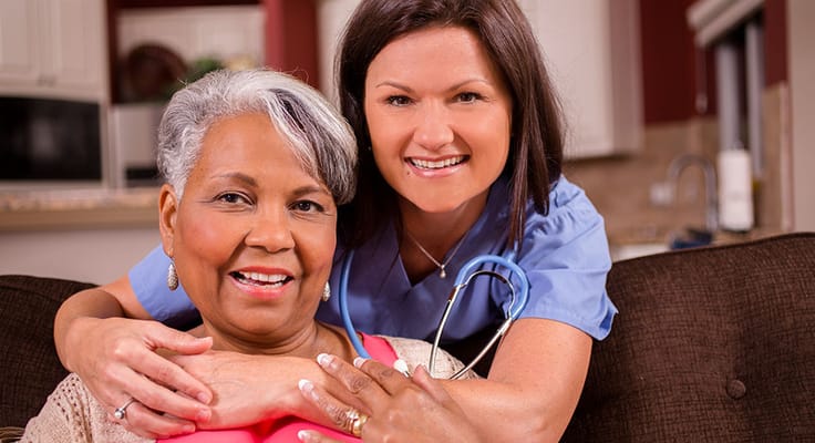 A caregiver smiling with a resident in a cozy living room