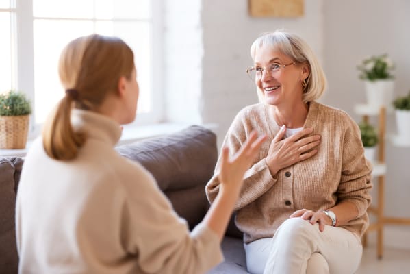 Two women engaged in a warm conversation in a cozy living room