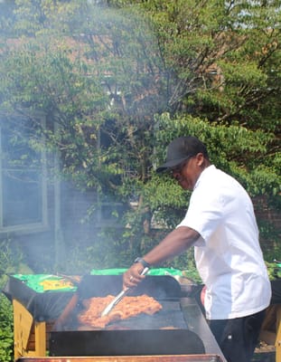 Cook grilling food at an outdoor event
