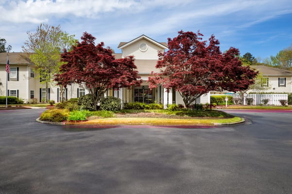 Exterior view of a senior living facility with landscaped entrance