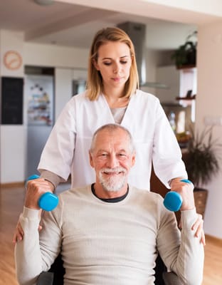 Therapist assisting resident with weights in a bright activity space