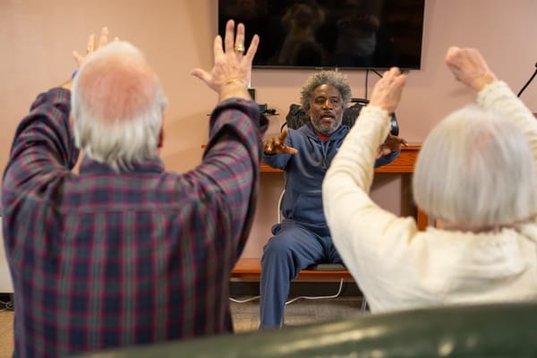 Residents participating in an exercise activity led by a staff member