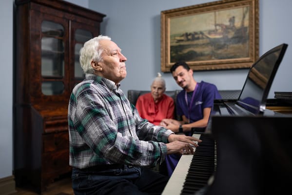 A resident playing piano with staff in the background