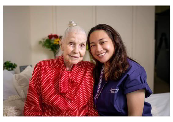 Resident and staff member smiling together in a room