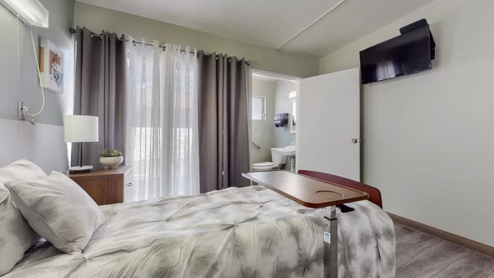 A cozy resident room with a bed and amenities