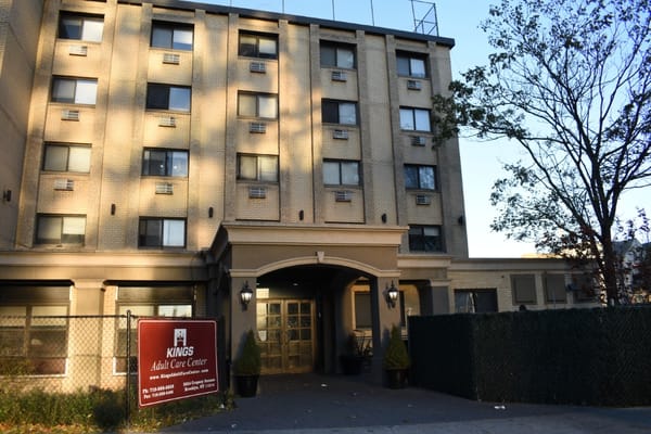 Main entrance of Kings Adult Care Center with sign and landscaping.