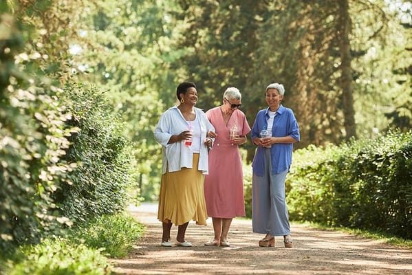 Three women enjoying a walk on a path through greenery