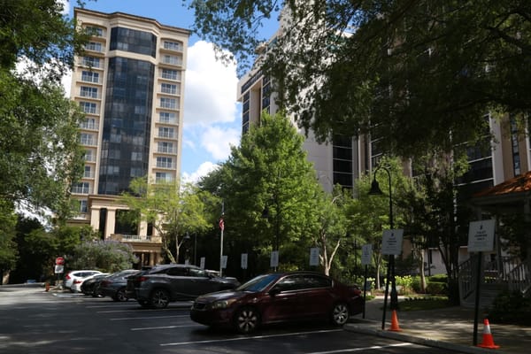 View of Renaissance on Peachtree with trees and parked cars