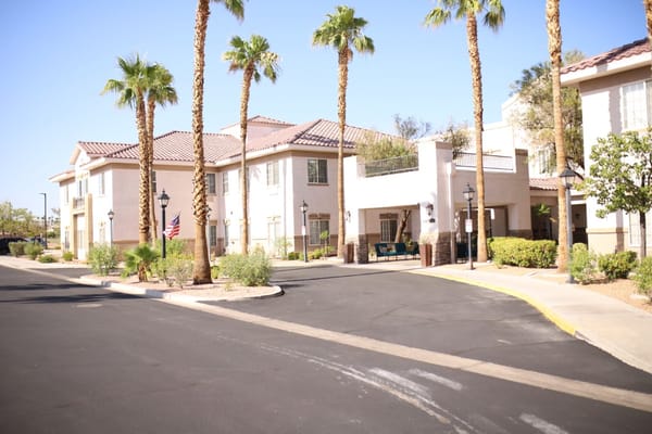 Exterior view of Heritage Springs senior living facility featuring palm trees.