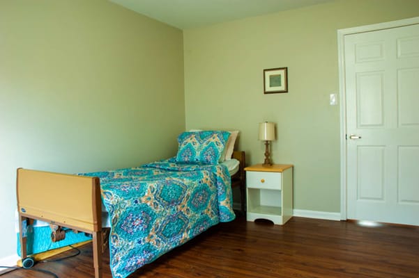 Bright private resident room with a bed and nightstand