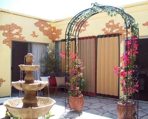 A serene outdoor garden area with a fountain and flowers