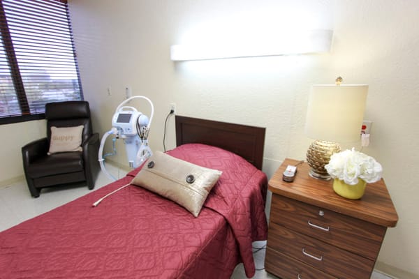 Interior photo of a resident room with bed and chair
