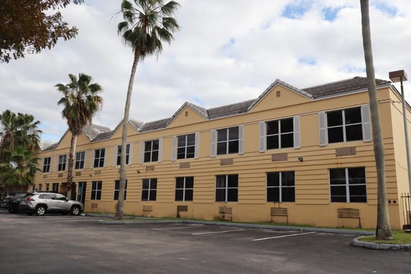 Exterior view of Courtyard Plaza facility with palm trees