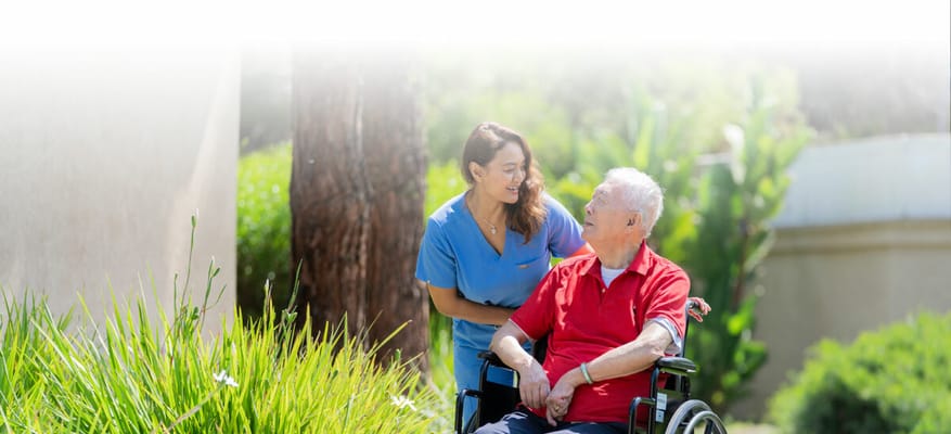 A caregiver and a resident outdoors in a garden