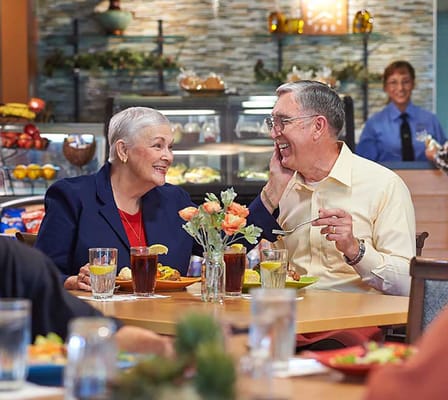 Residents enjoying a meal and conversation in the dining area