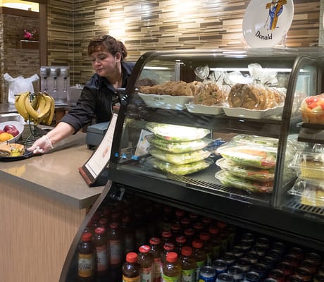 Staff serving meals in a dining area with fresh food