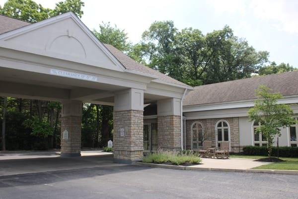 Entrance of a senior living facility with outdoor seating