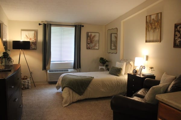 Well-decorated private resident room with a cozy bed