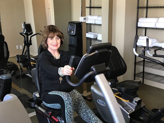 Resident exercising on a stationary bike in a fitness room