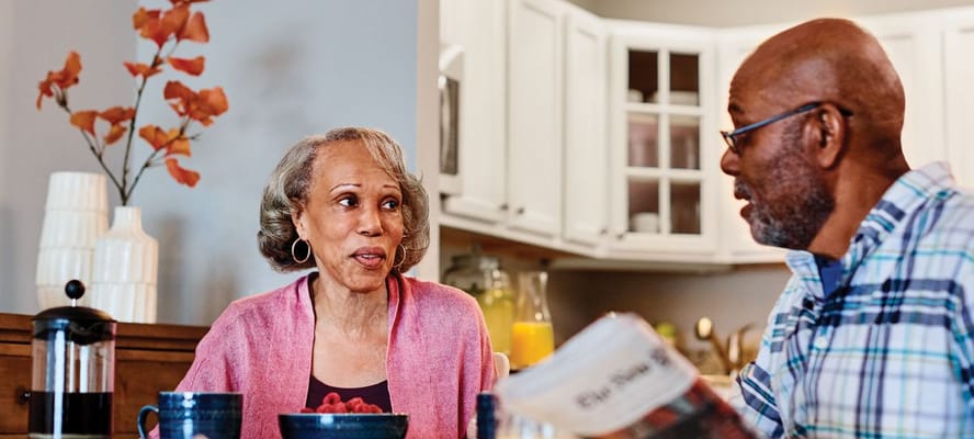 Two residents enjoying a conversation at a dining table