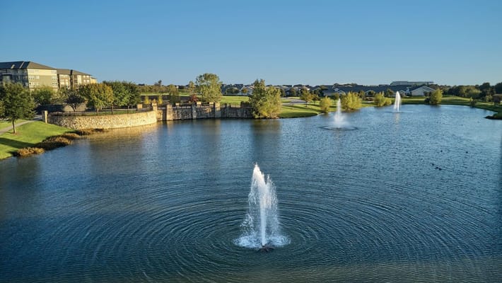 Scenic view of a peaceful pond with fountains