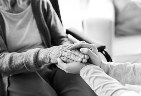 A caregiver holding hands with a senior resident